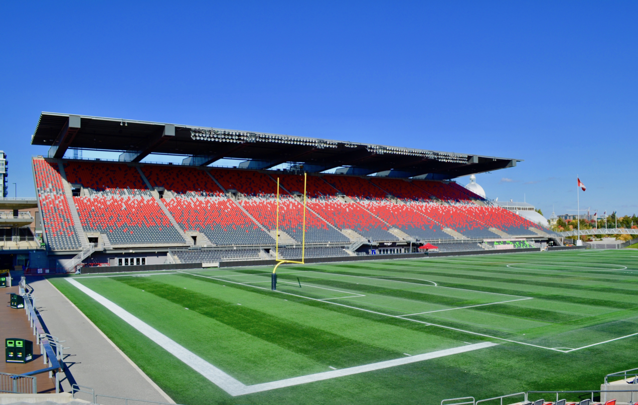 The north side stands at TD Place under a clear sky, with the Aberdeen Pavilion roof behind them.
